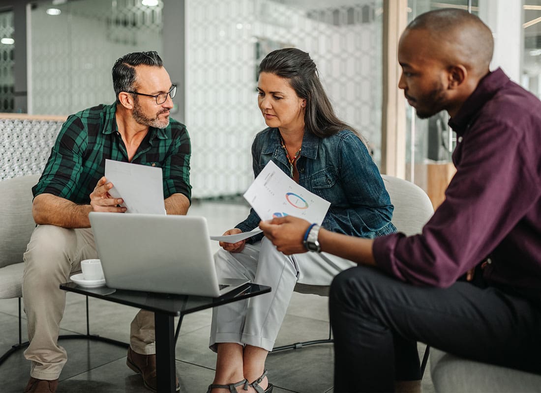 About Our Agency - Group Discussing Important Documents During a Meeting in the Office